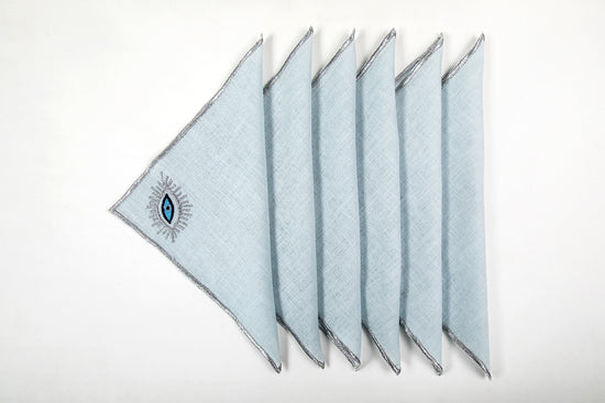 Powder blue linen cocktail napkins with evil eye embroidery.
