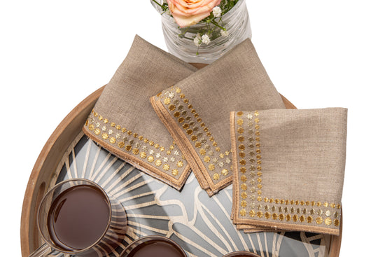 Natural linen cocktail napkins with delicate gold embroidery.