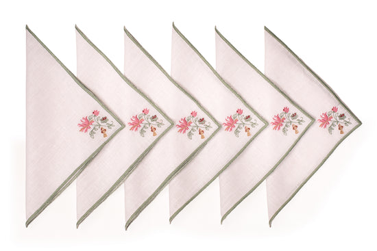 White linen cocktail napkin with mint green floral detailing.