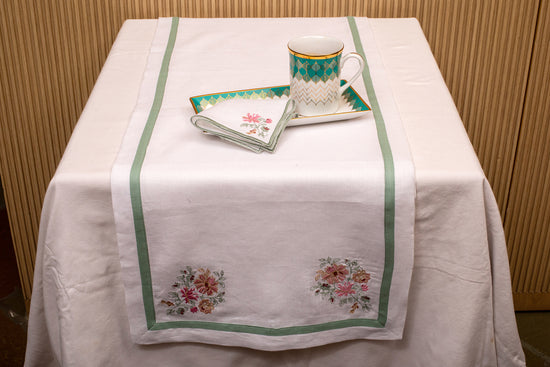 White linen embroidered runner with mint green floral detailing.