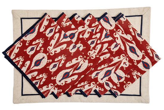 Cream linen placemats with maroon batic print napkins.