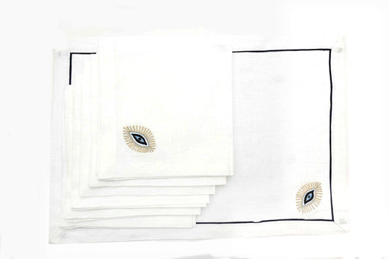White linen placemats and napkins with Gold evil eye embroidered.