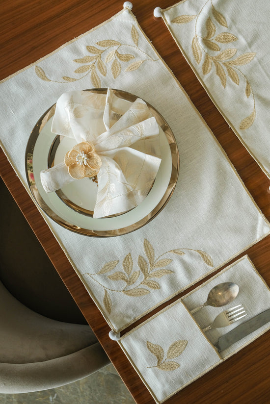 Cream linen embroidered cutlery holders.