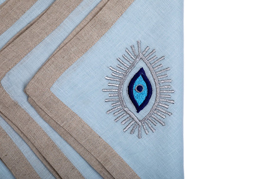 Powder blue linen dinner napkins with evil eye embroidered.