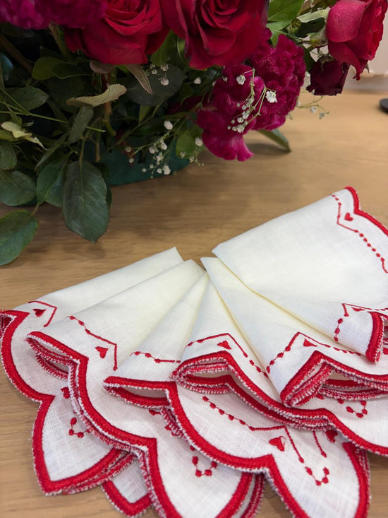 Cream linen cocktail napkins with heart embroidery.