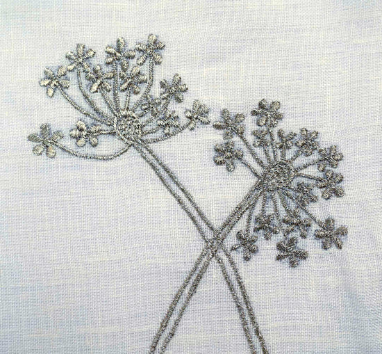 Ruffled cream embroidered linen placemats with ruffled linen napkins.