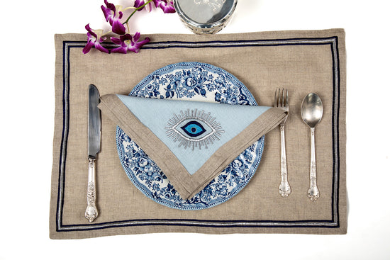 Natural linen placemats with embroidery and embroidered powder blue napkins.