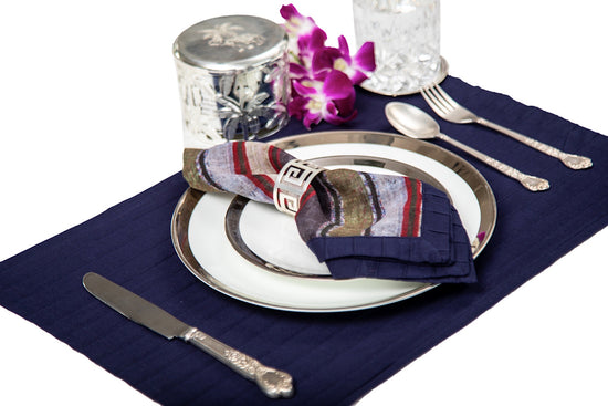 Navy blue linen pleated placemats with blue and red striped linen napkins.