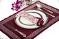 Wine coloured embroidered linen placemats with printed linen napkins.