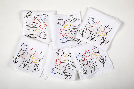 White linen cocktail napkins with  floral embroidery.