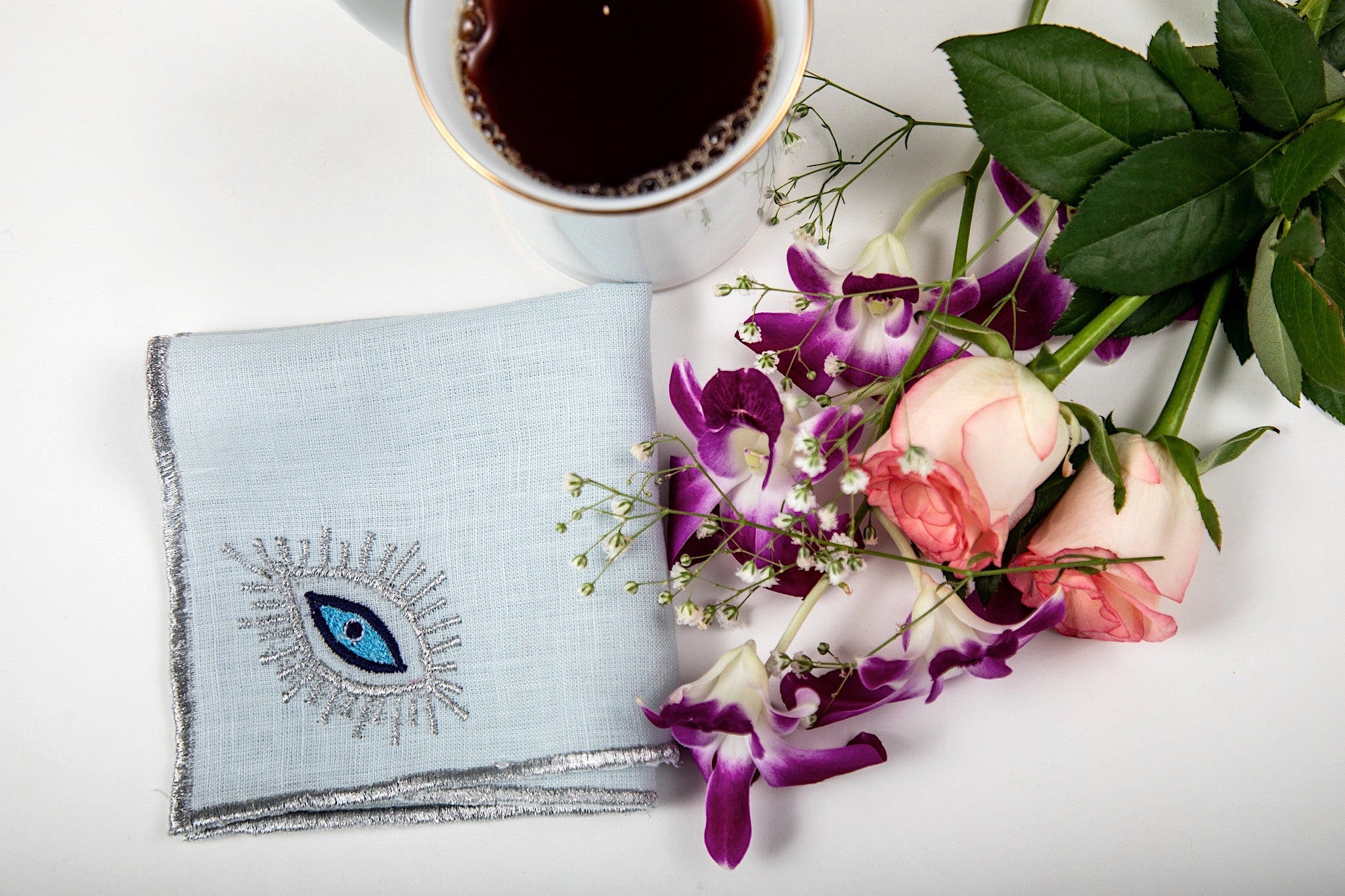 Powder blue linen cocktail napkins with  evil eye embroidery.