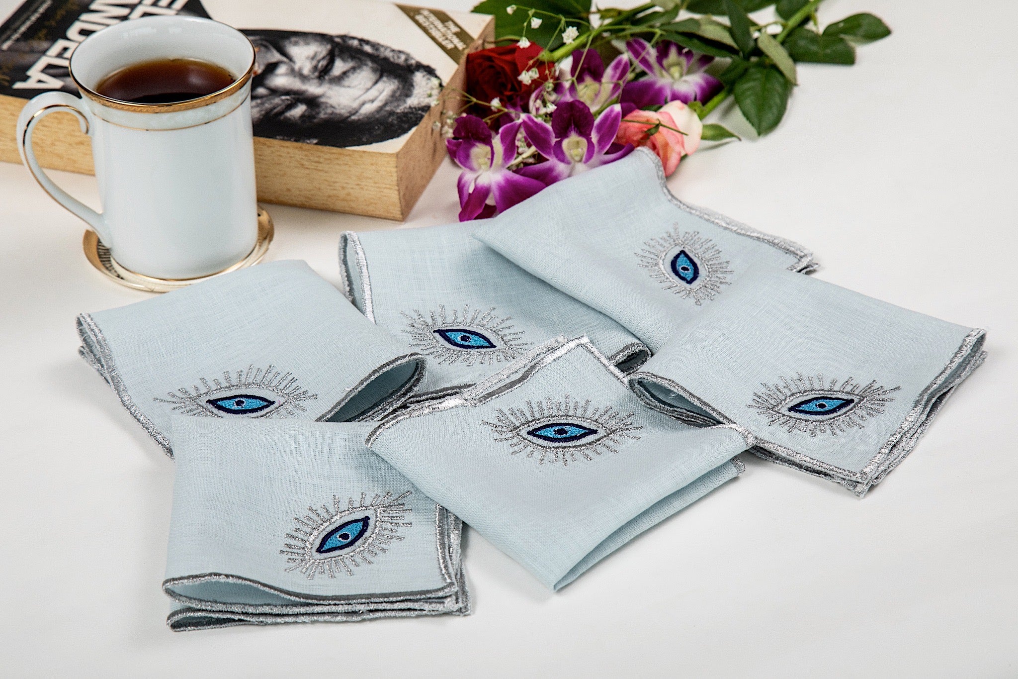 Powder blue linen cocktail napkins with  evil eye embroidery.