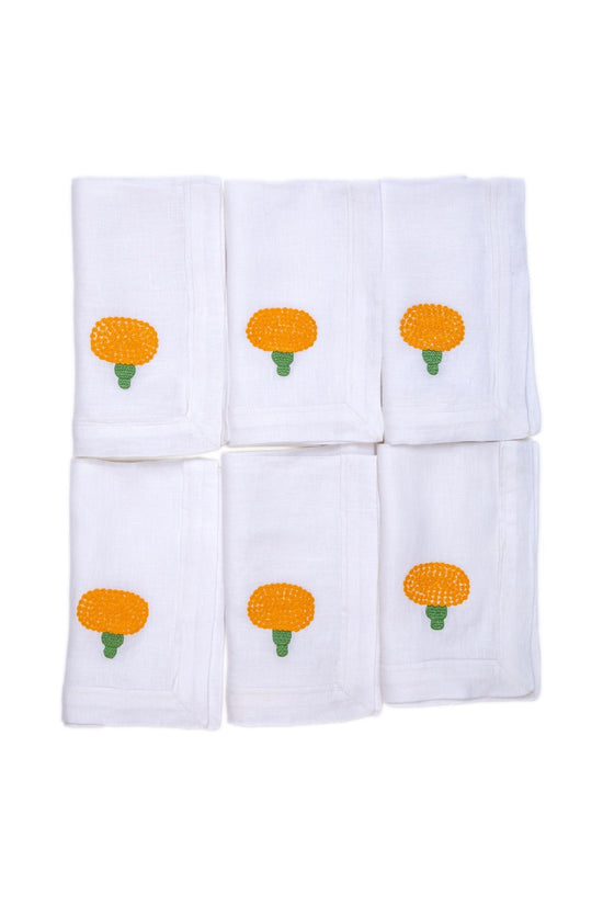 White linen dinner napkins with embroidered marigold.