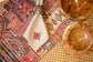 Red printed linen placemats with cream napkins.