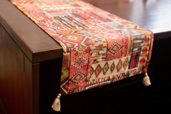 Red  printed runner with embroidery and tassels.
