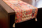 Red  printed runner with embroidery and tassels.