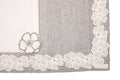 Laced striped placemats  and white linen dinner napkins with floral embroidery.