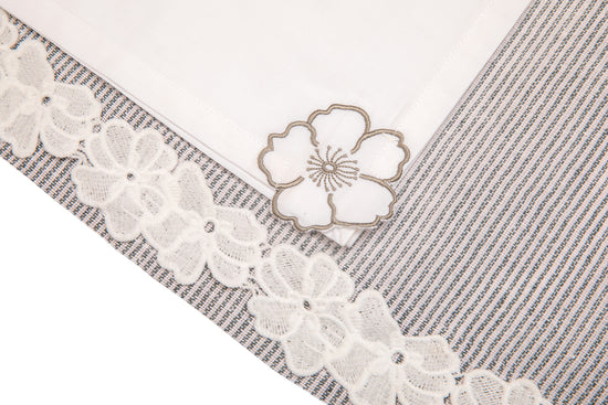 Laced striped placemats  and white linen dinner napkins with floral embroidery.