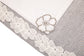 Laced striped placemats  and white linen dinner napkins with floral embroidery.