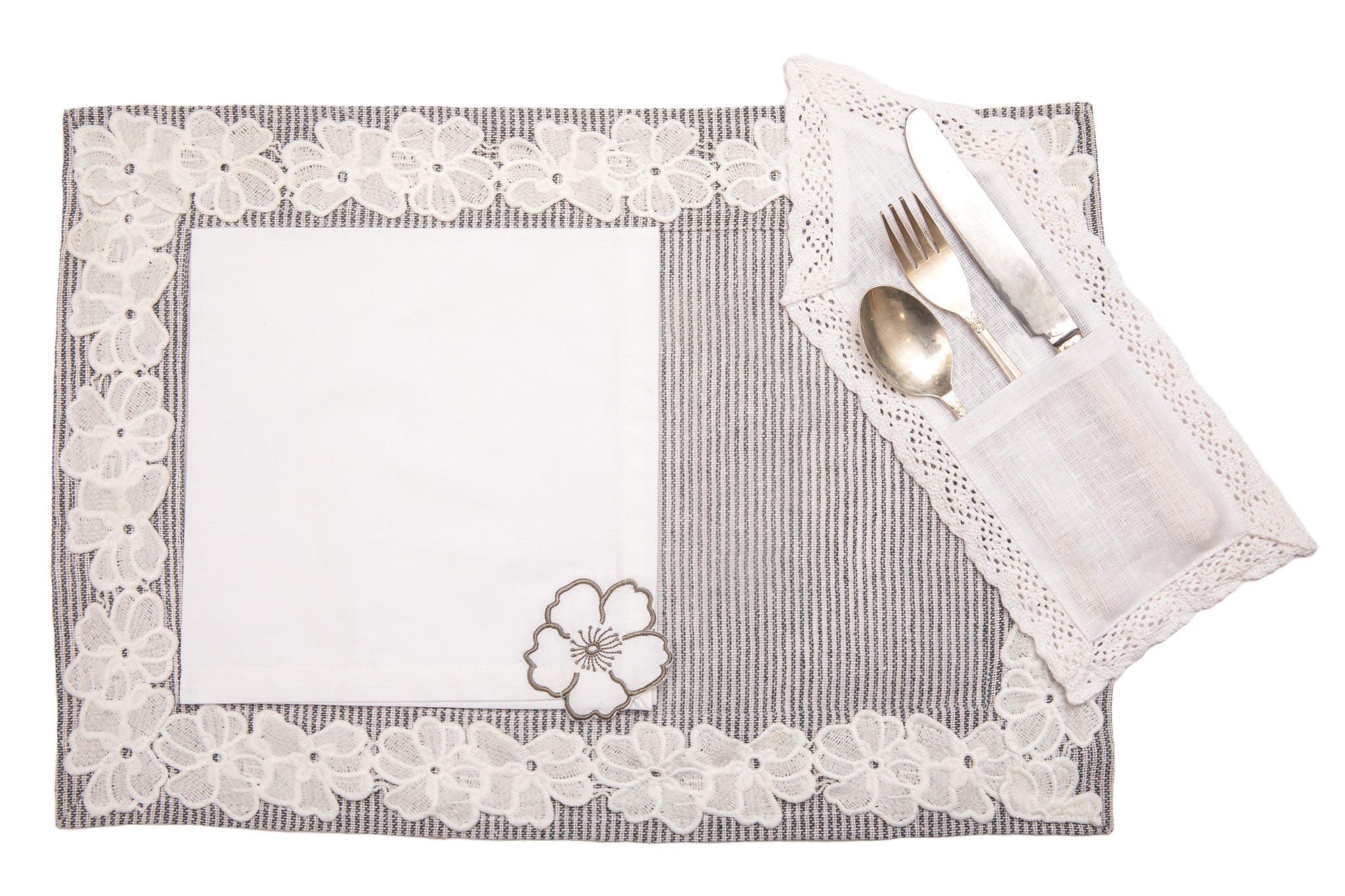 Laced striped placemats  and white linen dinner napkins with floral embroidery.
