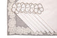 Laced striped placemats  and white linen dinner napkins with floral embroidery.