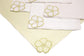Striped linen placemats and white linen napkins with floral embroidery.