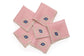 Pink linen cocktail napkins with embroidered evil eye.