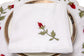 White linen dinner napkins with rosebud embroidery.