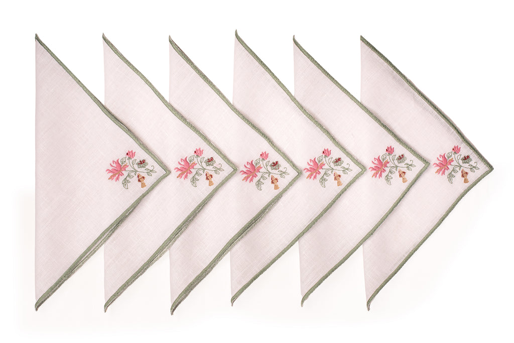 White linen cocktail napkin with mint green floral detailing.