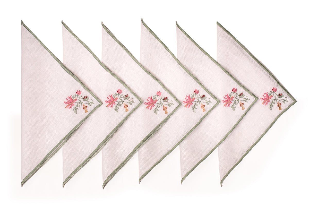 White linen cocktail napkin with mint green floral detailing.