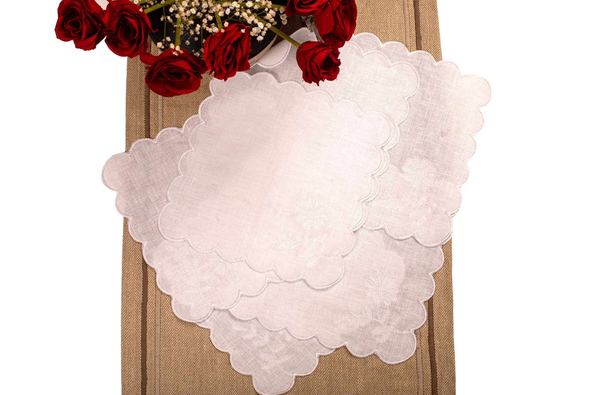 White linen scalloped and embroidered cocktail napkin.