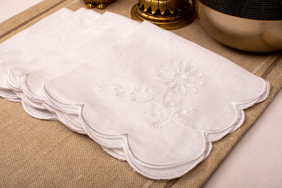 White linen scalloped and embroidered dinner napkin.
