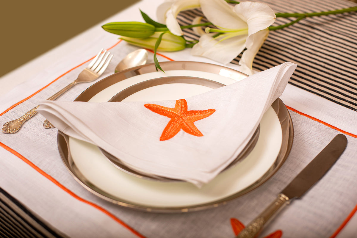 White linen placemat and napkin with striking starfish embroidery.
