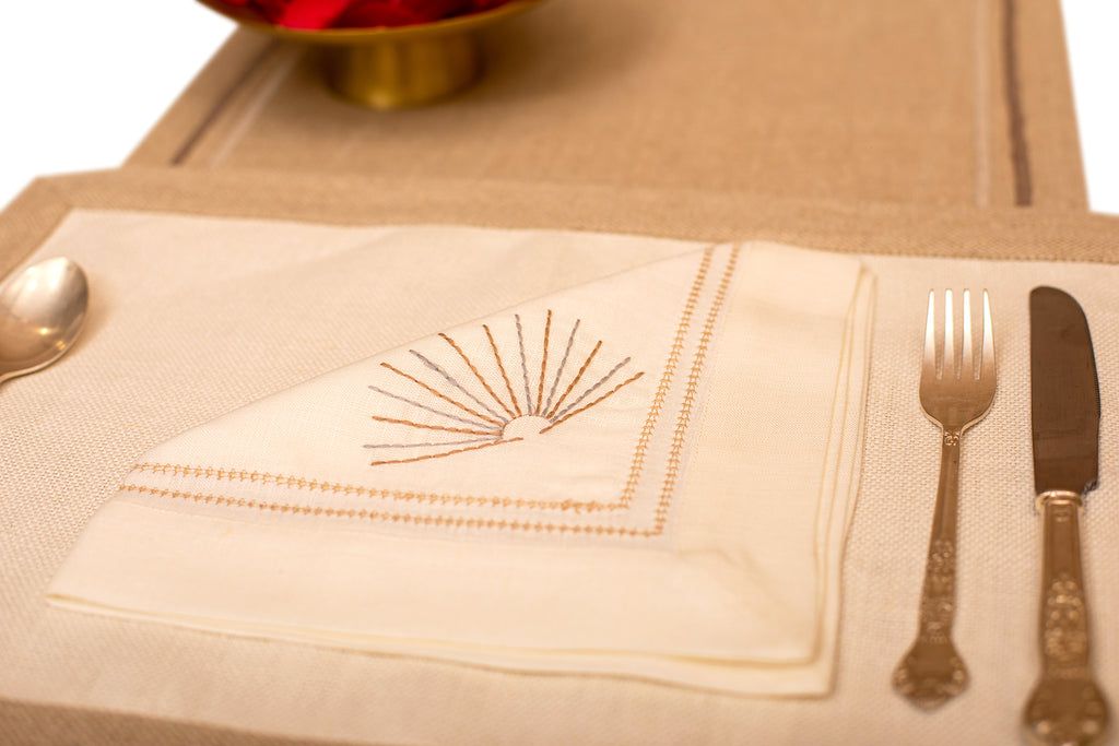 Cream linen placemat with  cream linen embroidered napkin.
