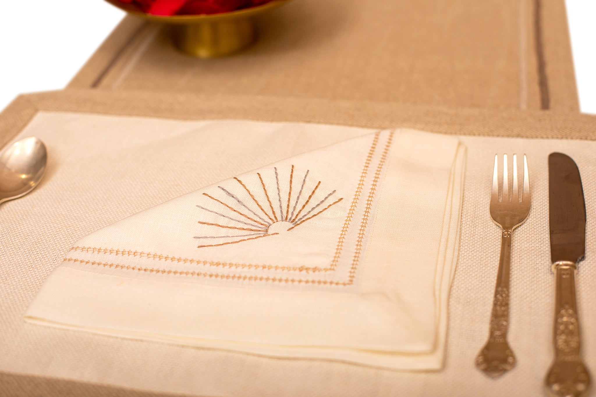 Cream linen placemat with  cream linen embroidered napkin.