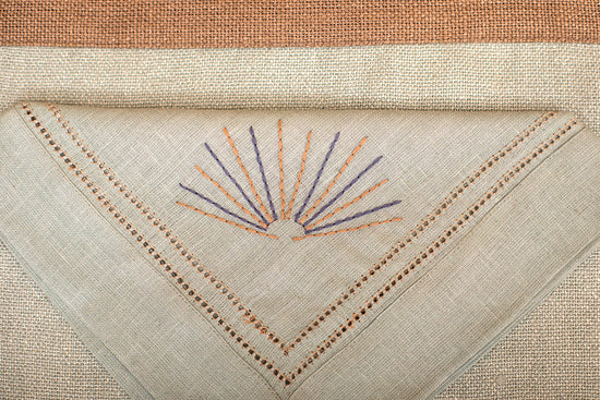 Slate blue linen  placemat with slate blue embroidered napkin.