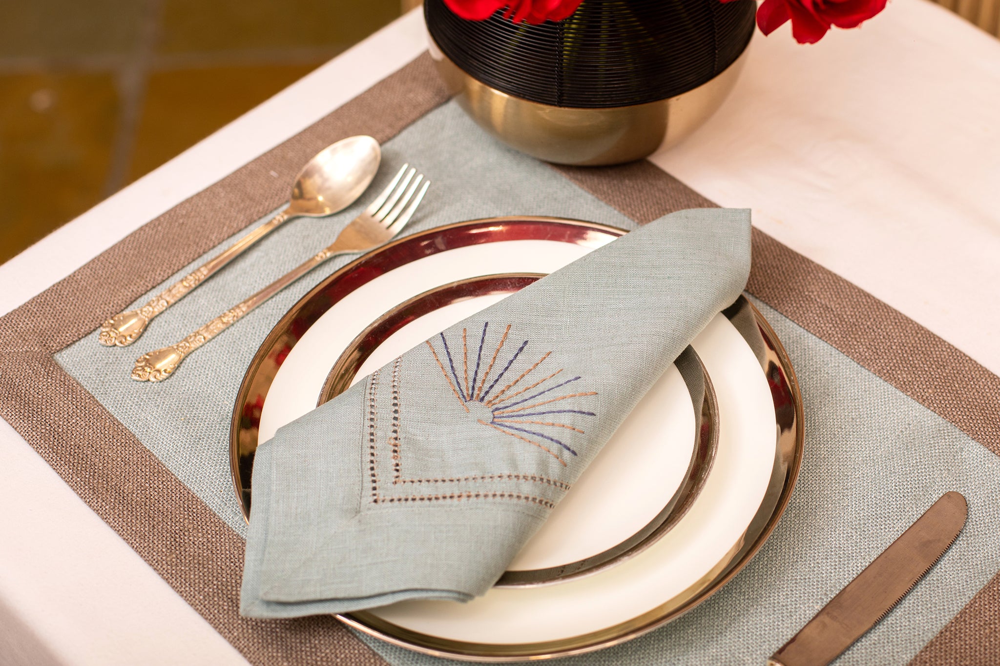 Slate blue linen  placemat with slate blue embroidered napkin.