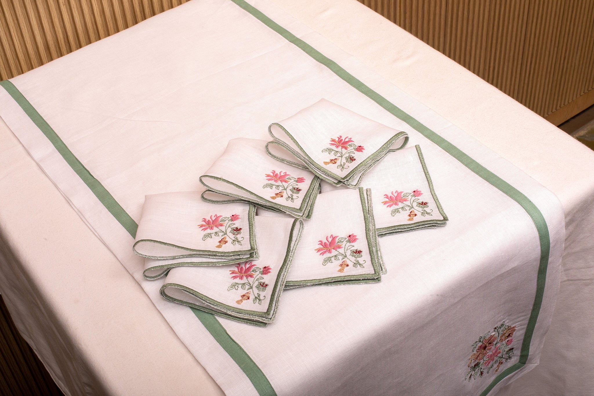 White linen embroidered runner with mint green floral detailing.
