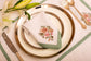 White linen embroidered placemat and napkin with mint green floral detailing.