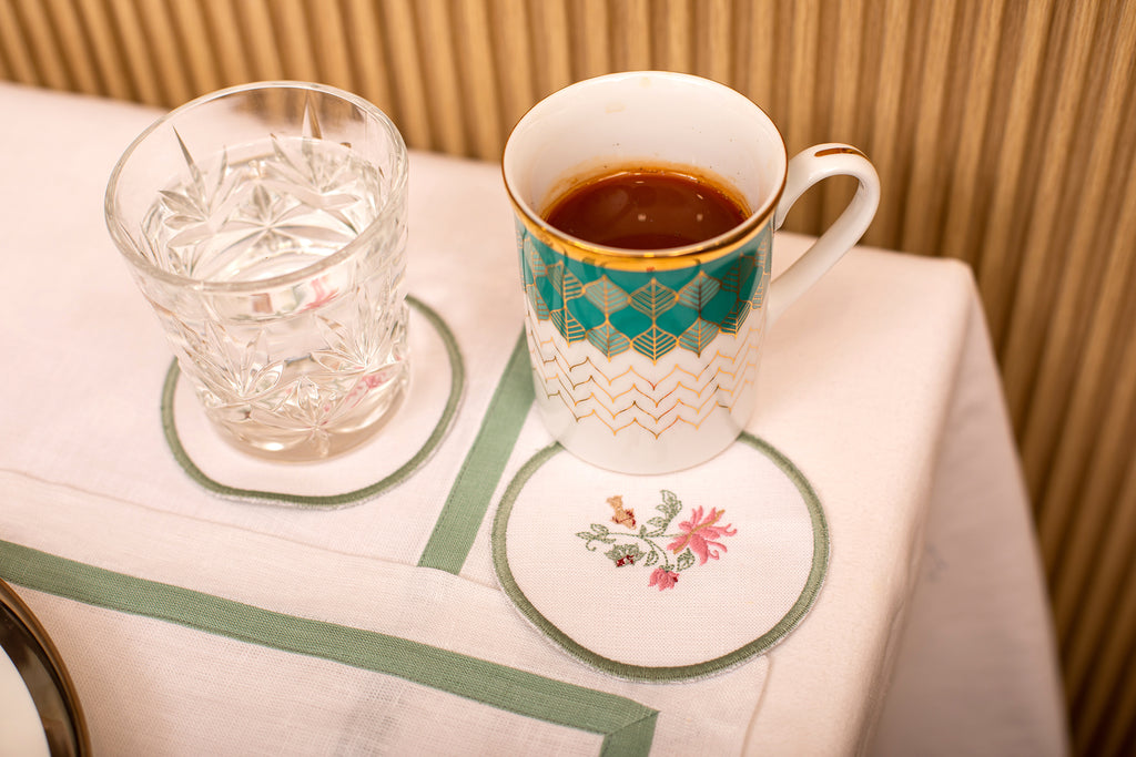 White linen embroidered  coaster with mint green floral detailing.