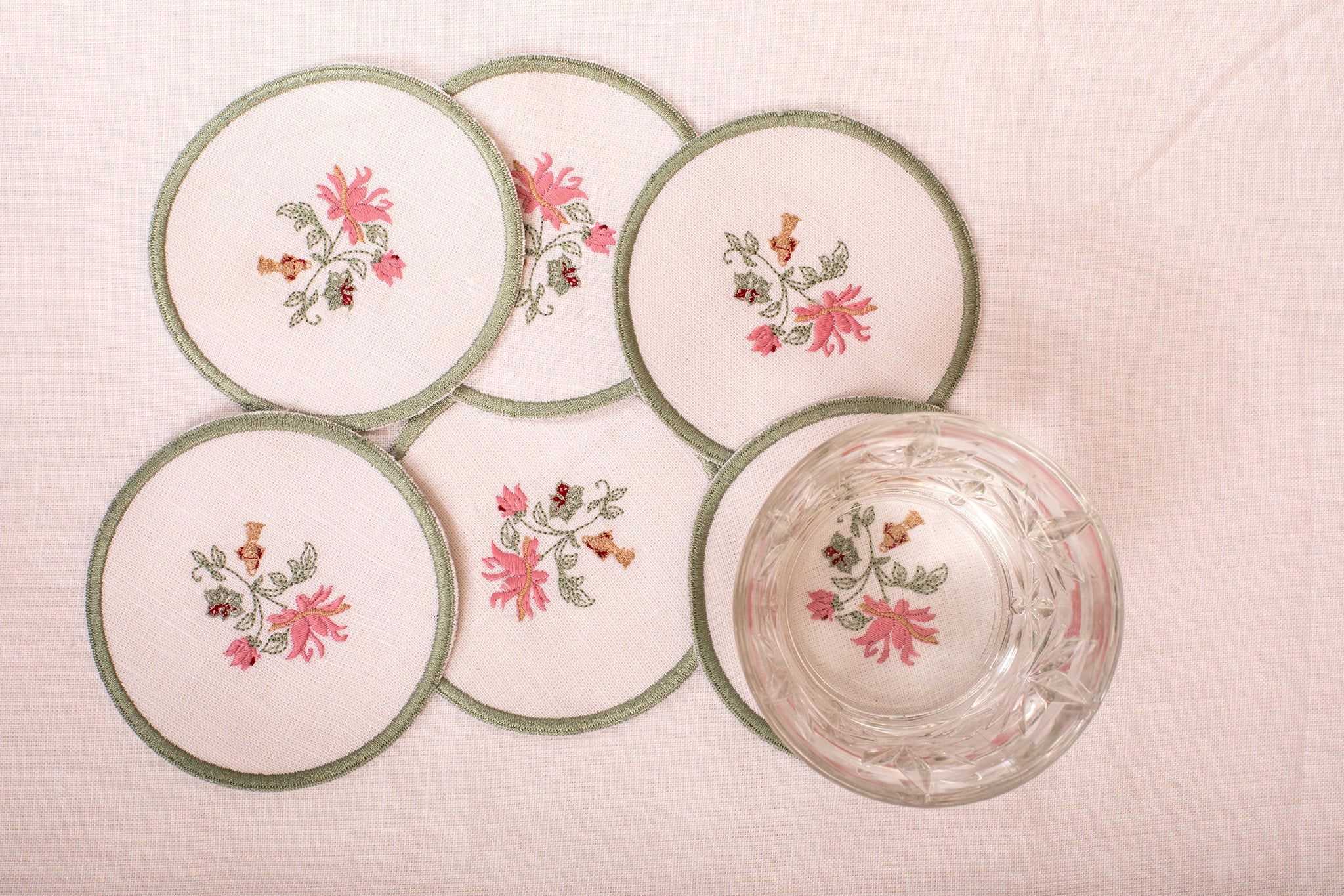 White linen embroidered  coaster with mint green floral detailing.