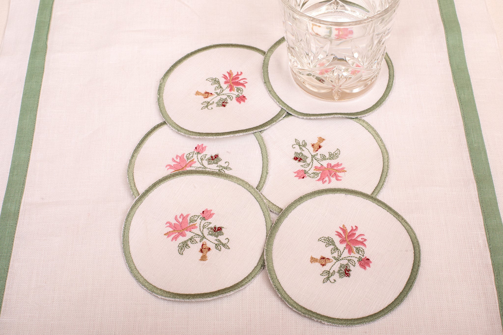 White linen embroidered  coaster with mint green floral detailing.