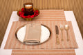 Rust and silver striped linen placemat and beige embroidered linen napkin.