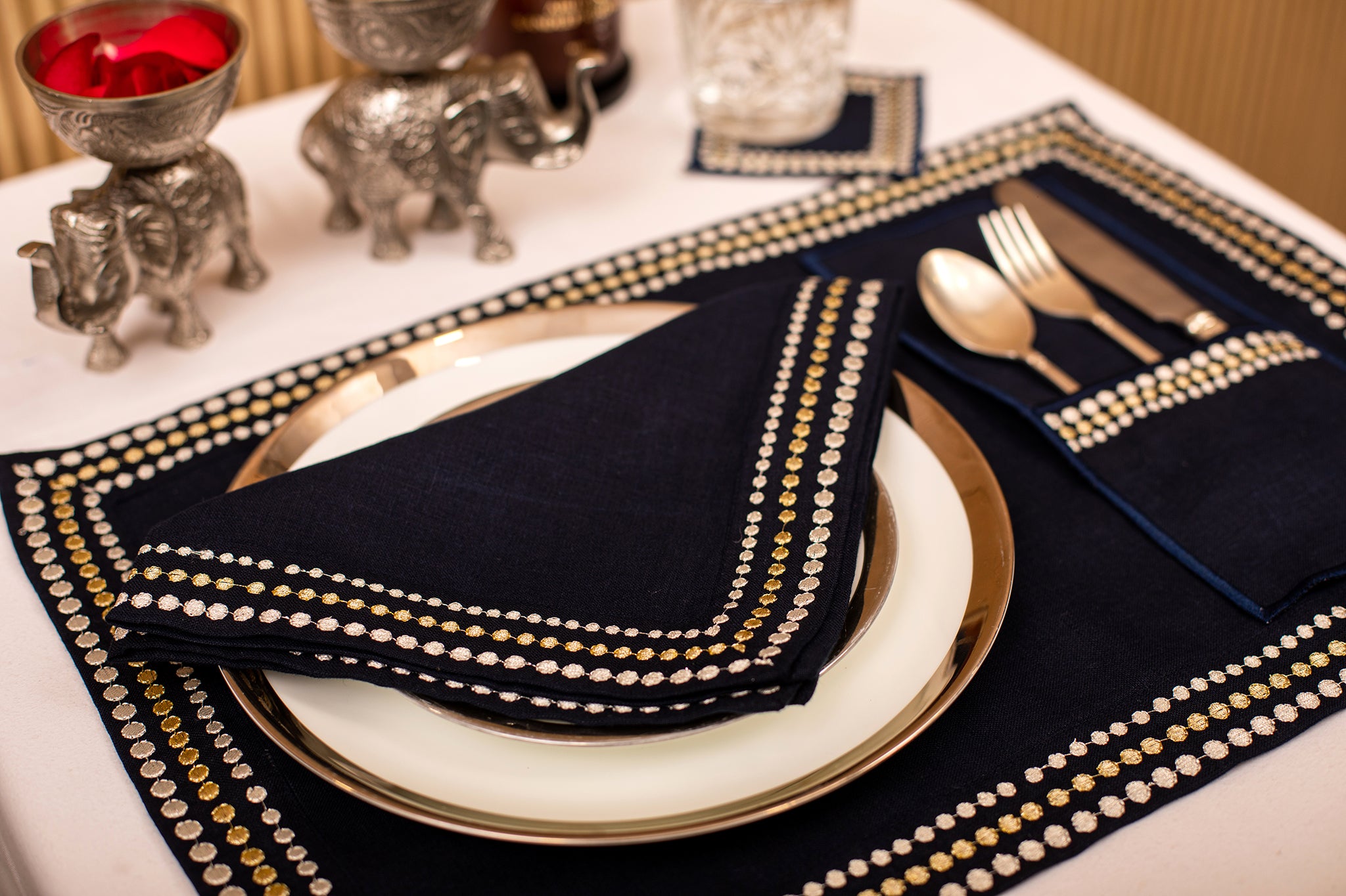 Navy blue linen placemat and  napkin with silver embroidery.