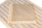 Blue and beige striped linen placemat and napkin with lace detailing.