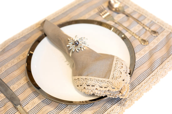 Blue and beige striped linen placemat and napkin with lace detailing.
