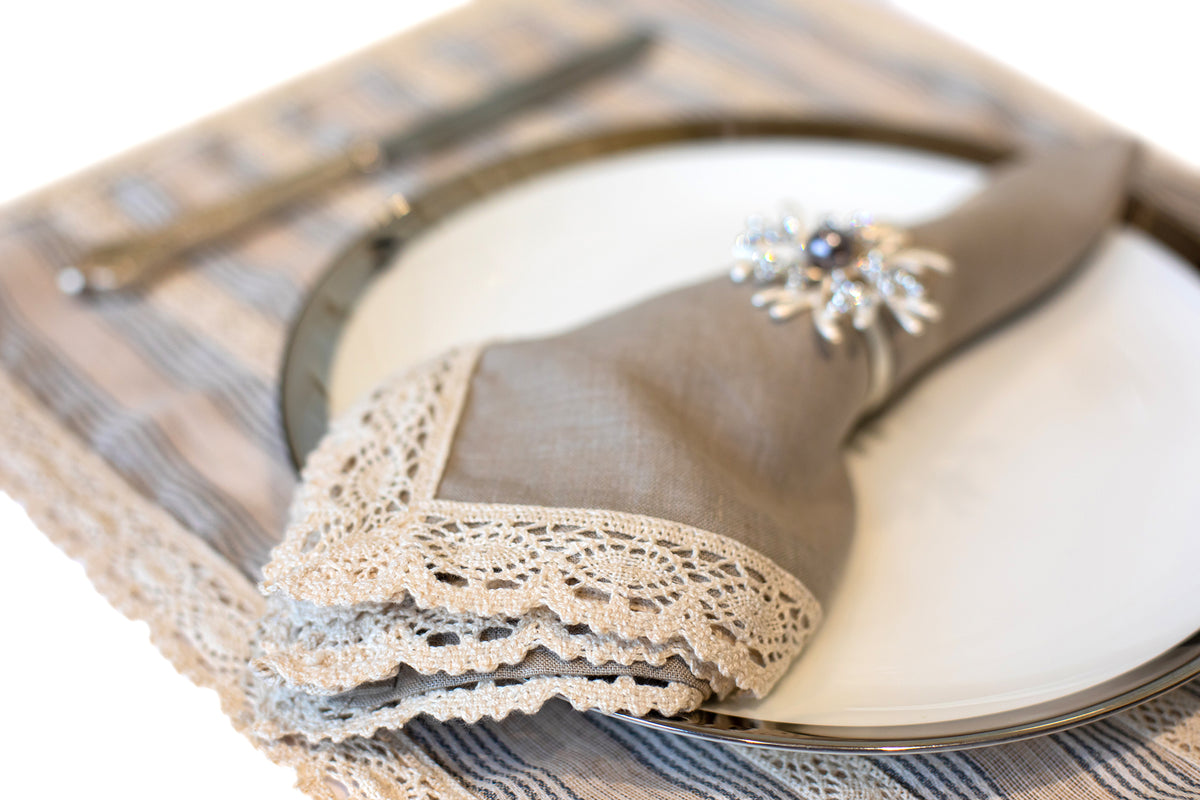 Blue and beige striped linen placemat and napkin with lace detailing.