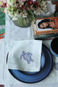 Powder blue linen placemats and napkins with embroidered turtle.