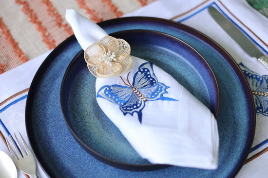 White linen placemats and napkins with embroidered butterfly.