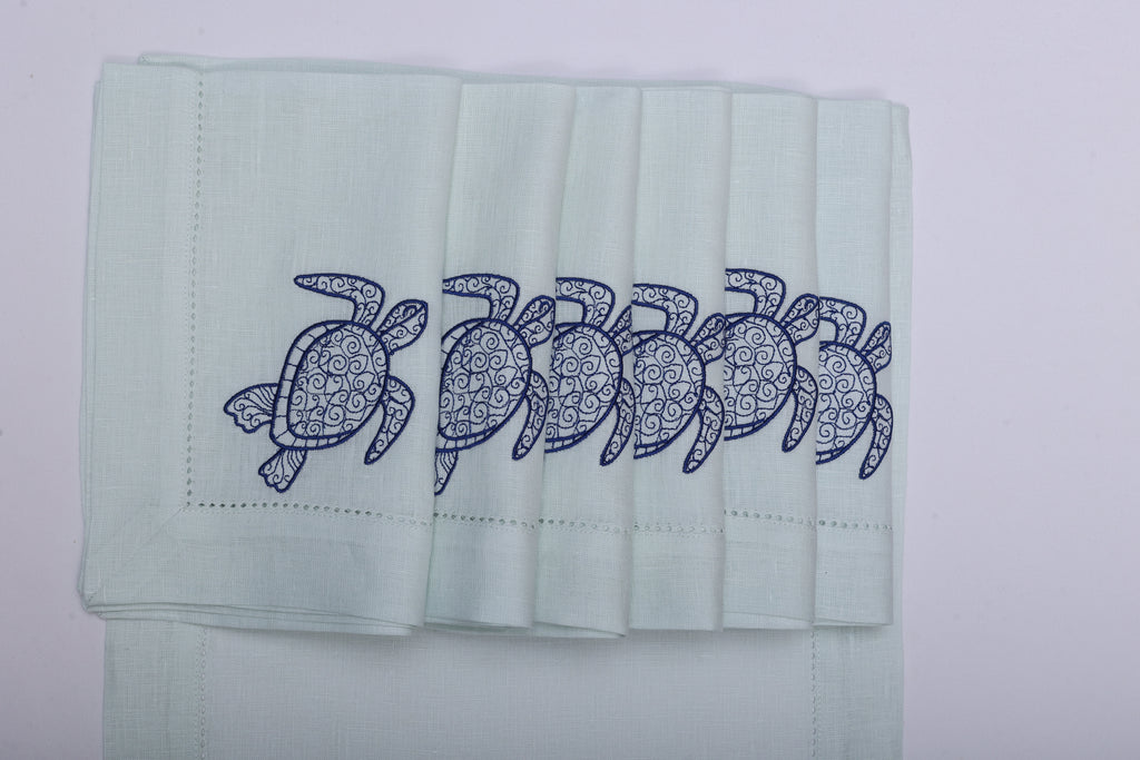 Powder blue linen placemats and napkins with embroidered turtle.